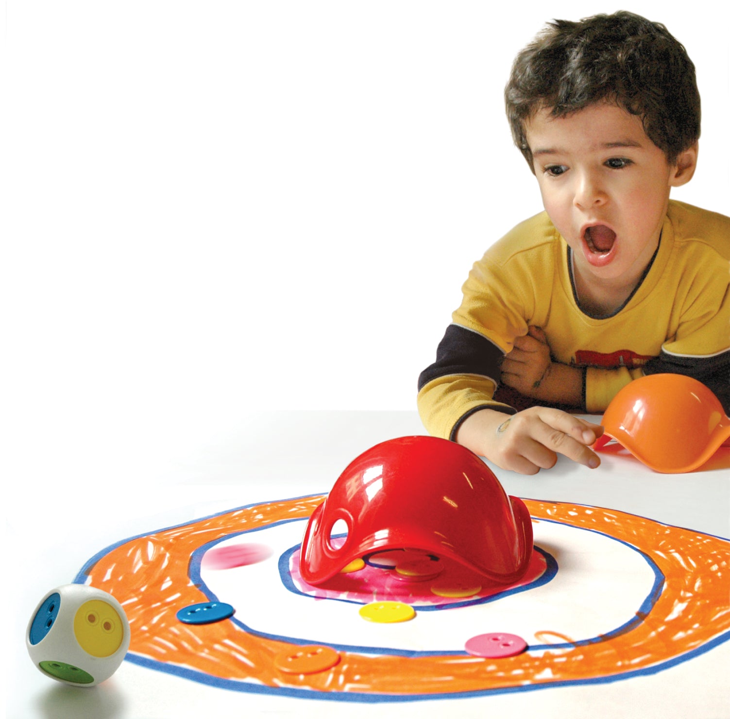 Child playing with the Bilibo Game Box by MOLUK, tossing colorful chips and using red and orange Bilibo Mini shells on a hand-drawn target.