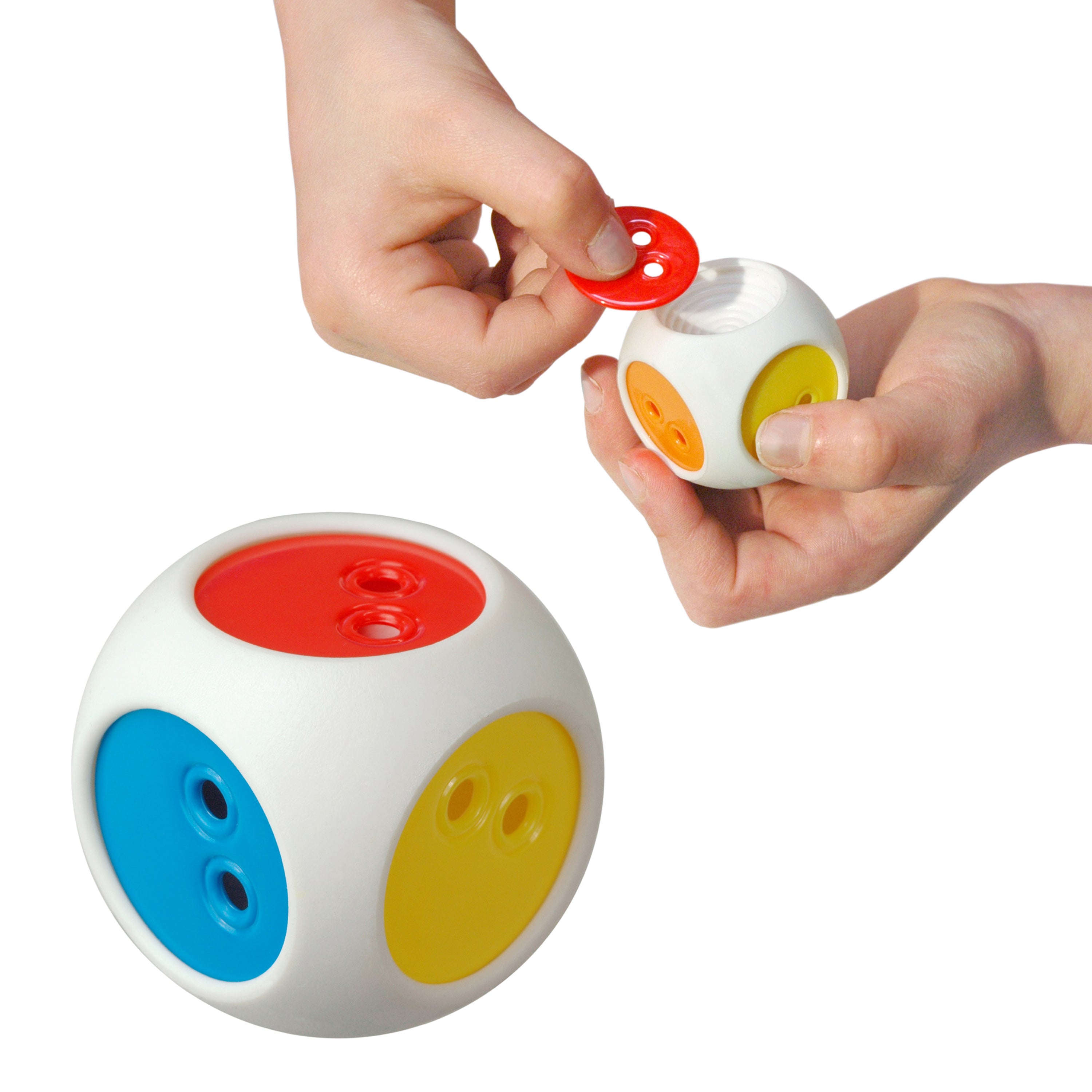 Hands inserting colorful chips into the elastic dice from the Bilibo Game Box by MOLUK, showing interchangeable color sides.