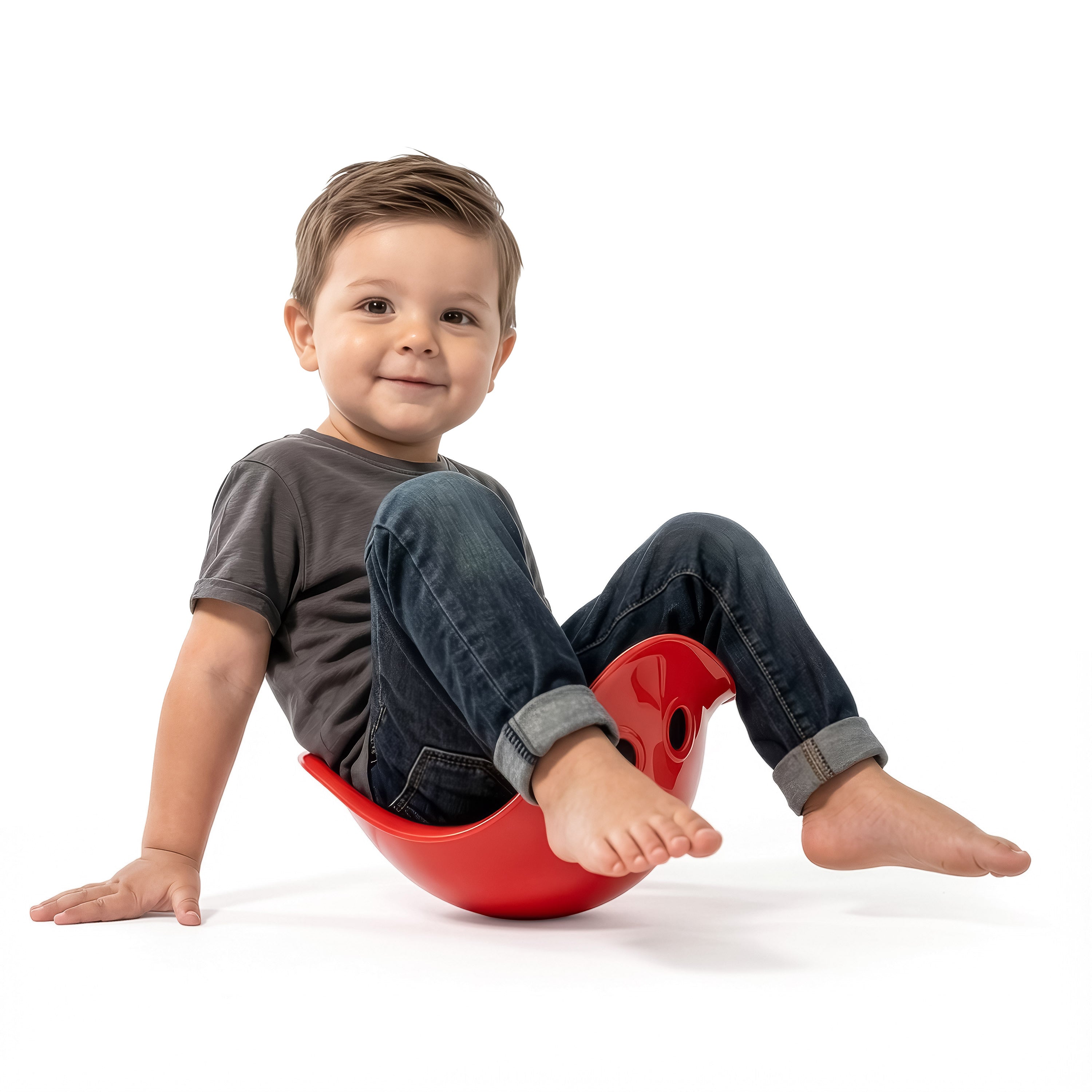 Toddler sitting and rocking in red Bilibo Midi – balance and movement play