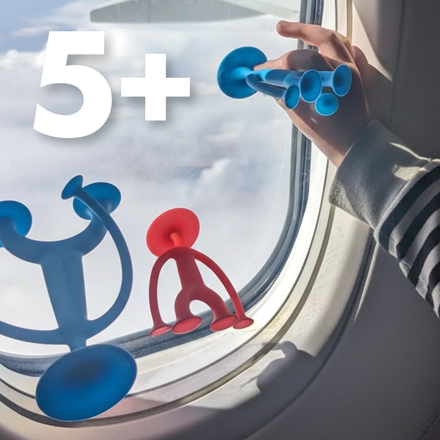 Suction cup Oogi figures by MOLUK stuck to an airplane window, child playing with the silicone toys, “5+” age label shown.