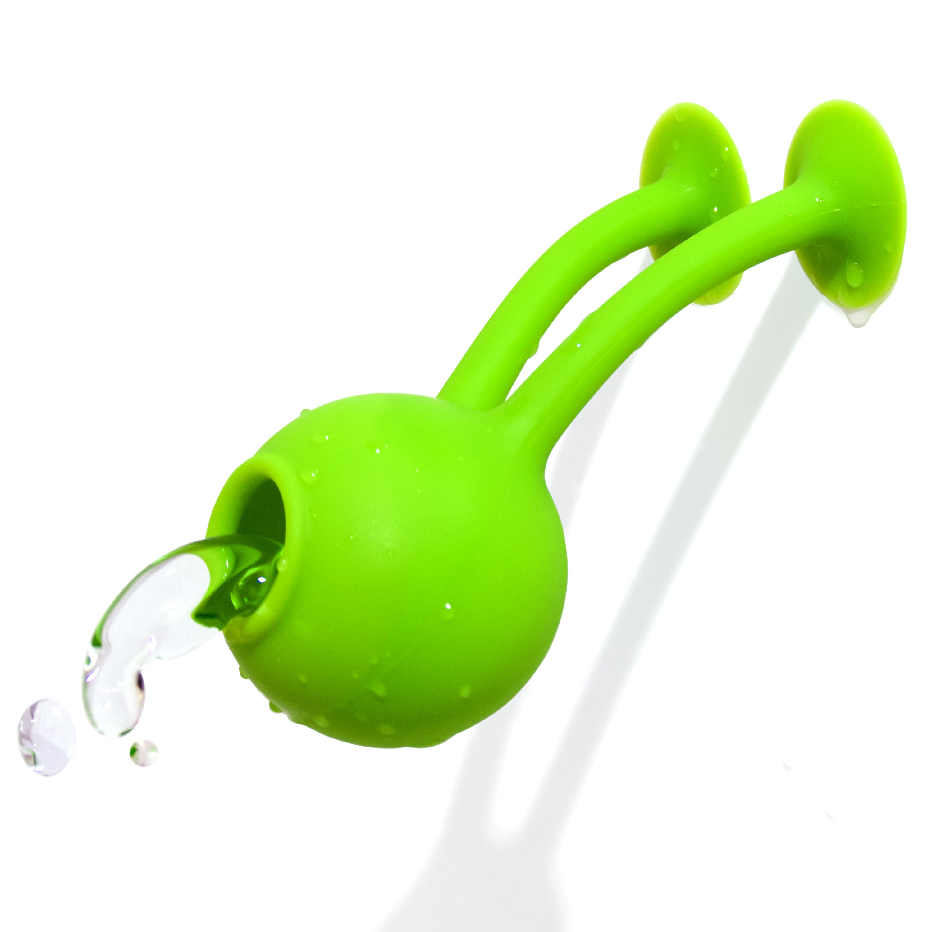 Green Oogi Bongo suction cup silicone toy by MOLUK, with both suckers attached to the bathroom wall, splashing water.