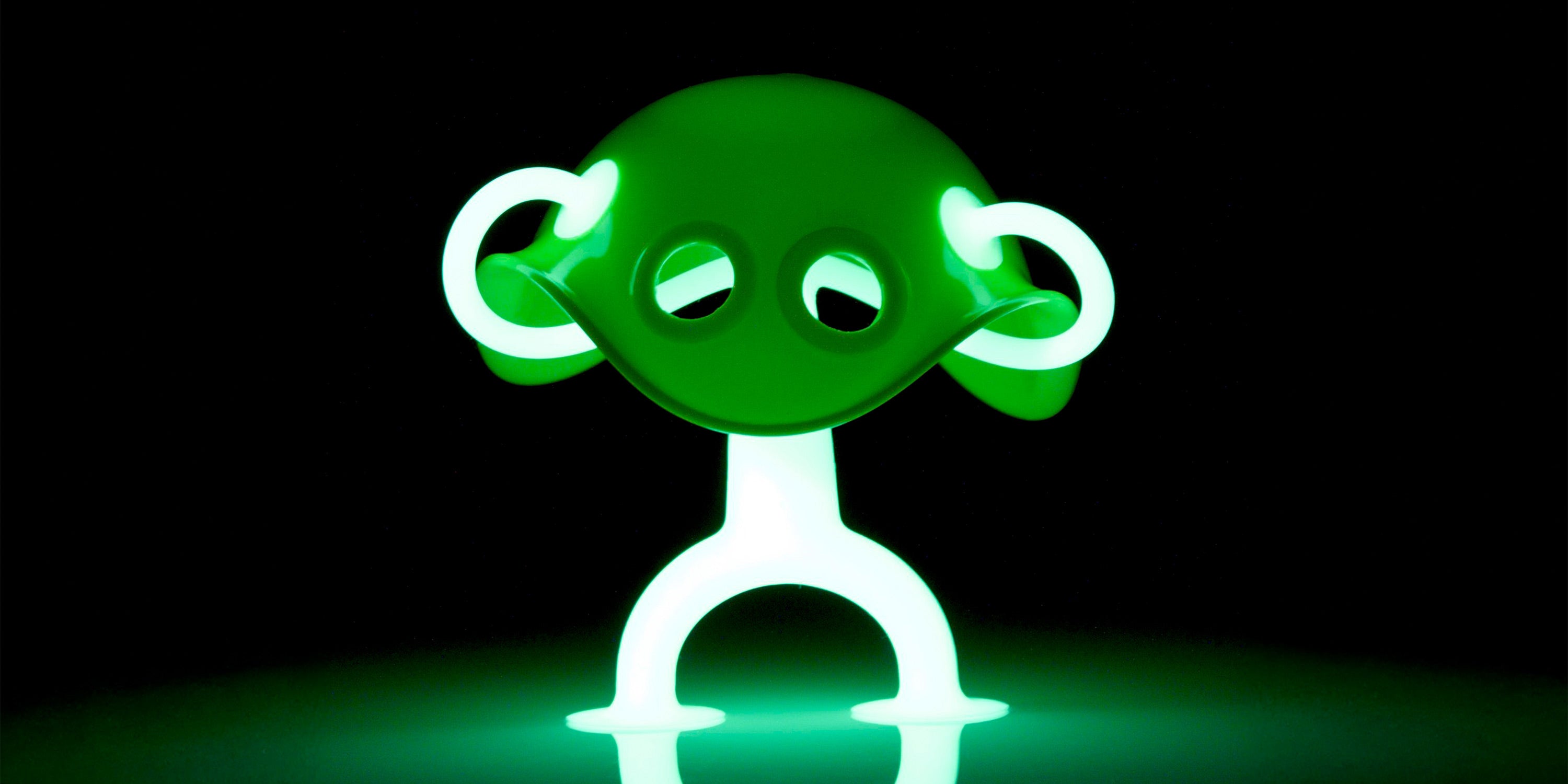 Oogi GLOW by MOLUK glowing bright green in the dark, combined with a Bilibo Mini shell, forming a funny alien character.