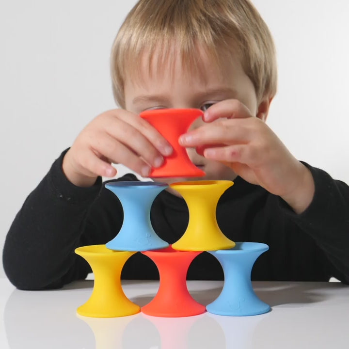 Video showing Tulu silicone building blocks by MOLUK in bright primary colors being stacked, nested, rolled, and combined in creative, open-ended ways.