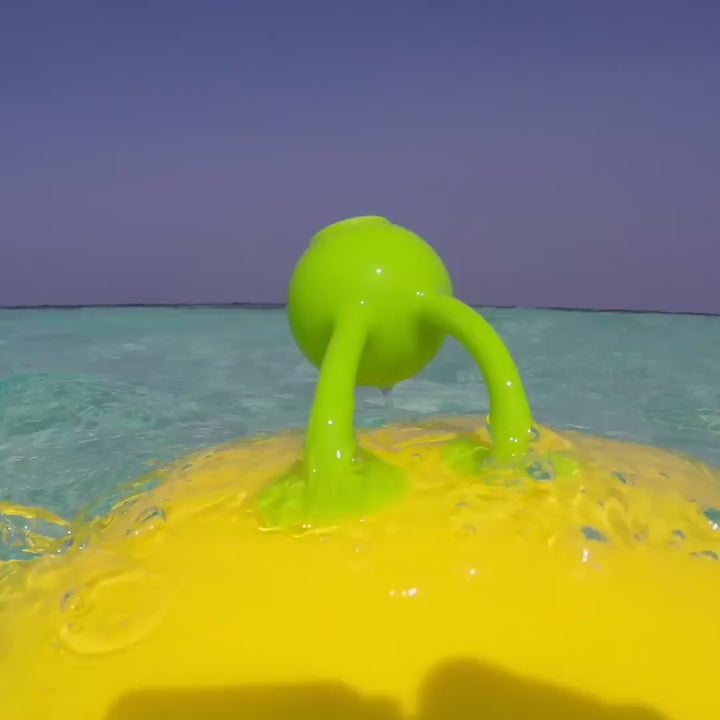 Video showing Oogi Bongo by MOLUK – a green silicone character with a round body and suction cup limbs – sticking, rattling, splashing in water, and used for playful sensory exploration.