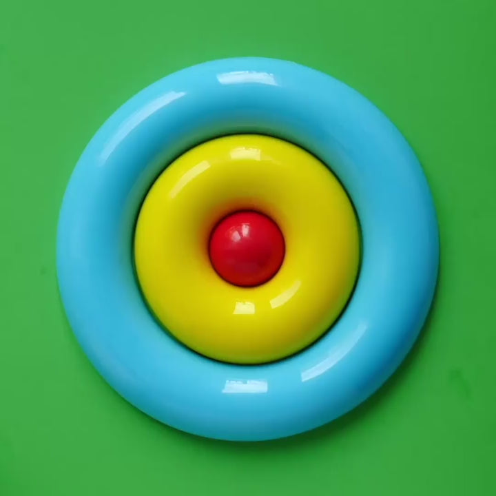 Nello color puzzle and skill toy by MOLUK shown in action with the centre piece rolling around the outer ring.