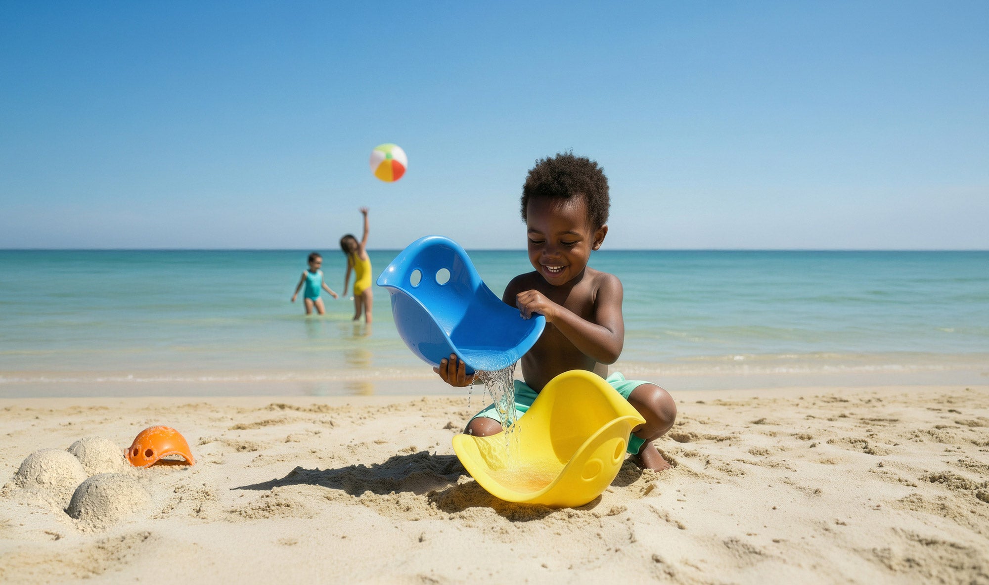Child playing with Bilibo Midi shells at the beach – pouring water and sand in open-ended sensory play