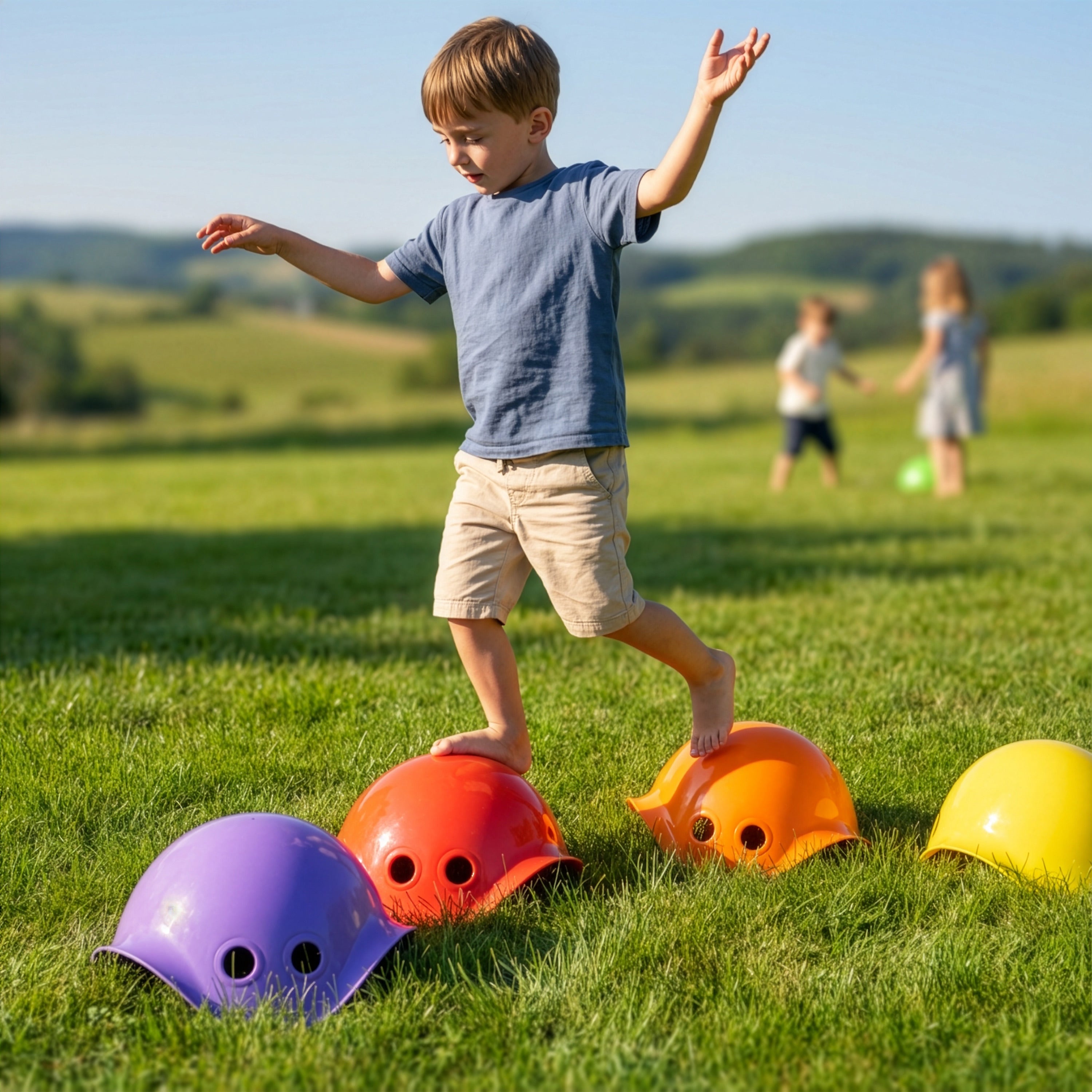 Boy balancing on colorful Bilibo stepping stones by MOLUK, on a grass field in the Swiss countryside.