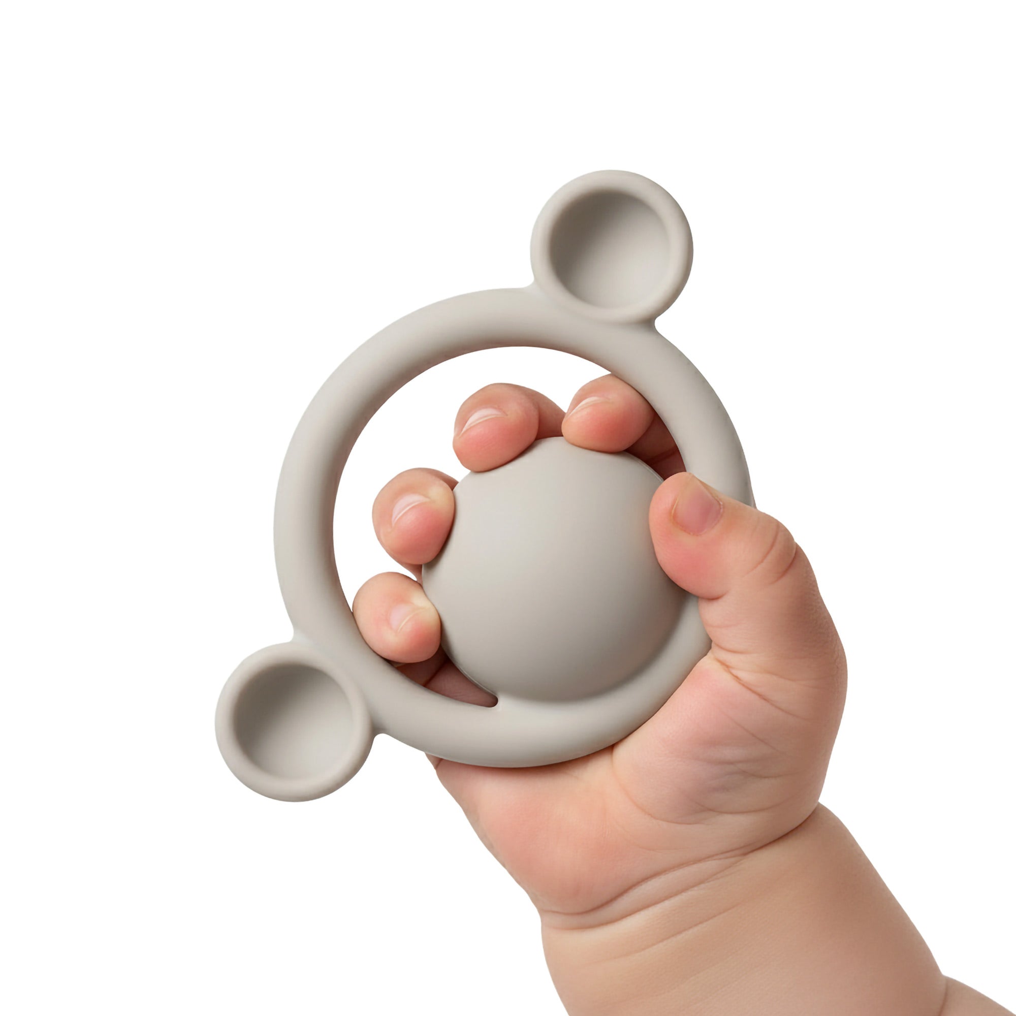 Baby hand holding a beige Nogi silicone teething ring 
