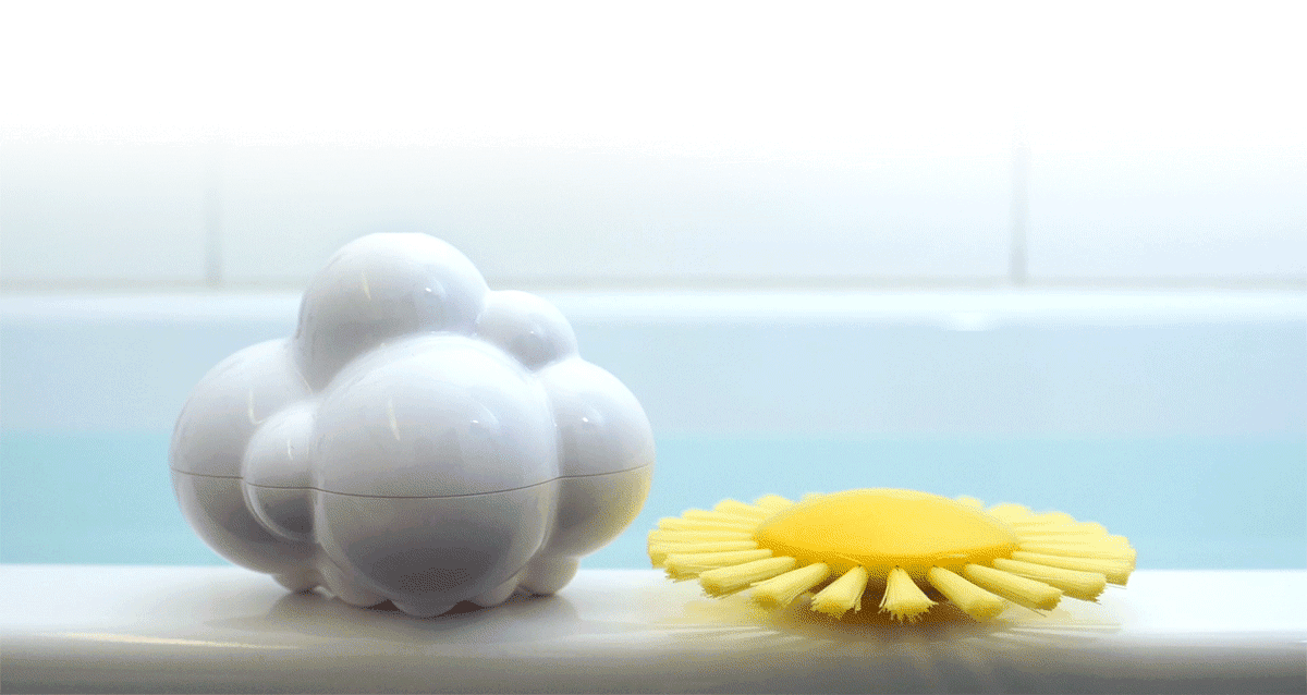 Pluï Rain Cloud and Sunny Brush by MOLUK resting on the edge of a bathtub, the cloud and sun-shaped toys ready for imaginative water play.