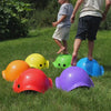Children playing outdoors with MOLUK toys in summer, splashing water with Pluï and Hix and balancing on Bilibo stepping stones.