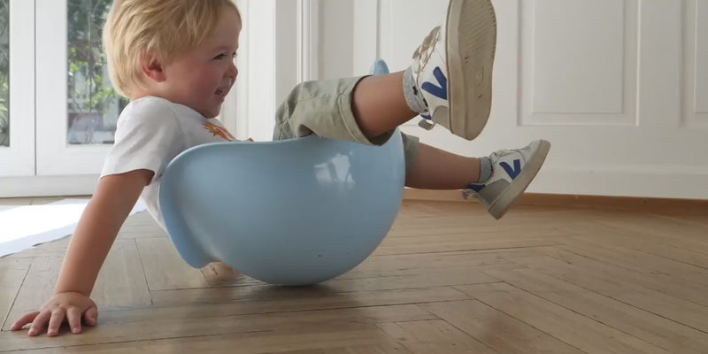 Video of children moving, rocking, and spinning with Bilibo and other MOLUK toys, exploring balance, coordination, and active play.