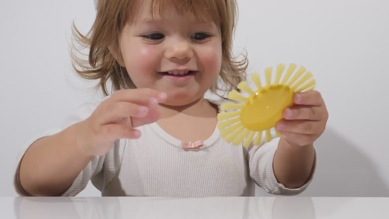 Video showing the Sunny Brush by MOLUK — a yellow sun-shaped sensory brush — spinning, floating, and used in water play and sensory exploration.