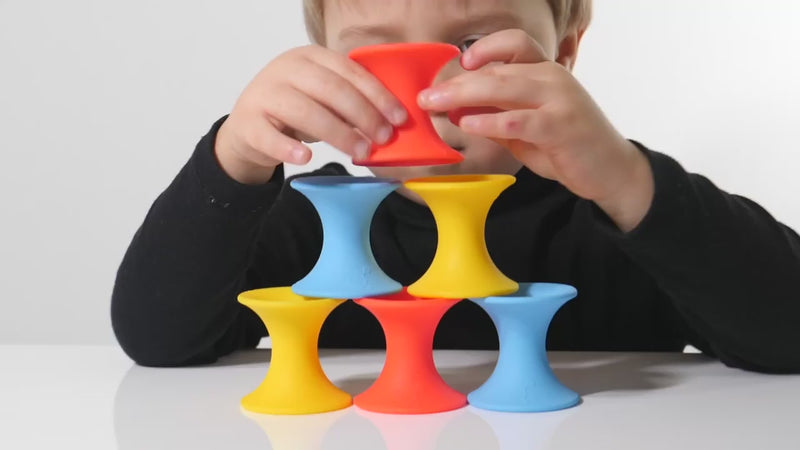 Video showing Tulu silicone building blocks by MOLUK in bright primary colors being stacked, nested, rolled, and combined in creative, open-ended ways.