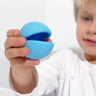Video showing Mox by MOLUK – a silicone sensory ball with a big mouth – being squeezed, stacked, rolled, and used for imaginative play, speech exercises, and simple games with children.